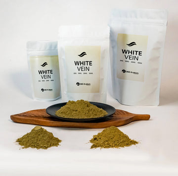 White vein kratom powder and packages displayed on a wooden plate for focus and mental alertness.